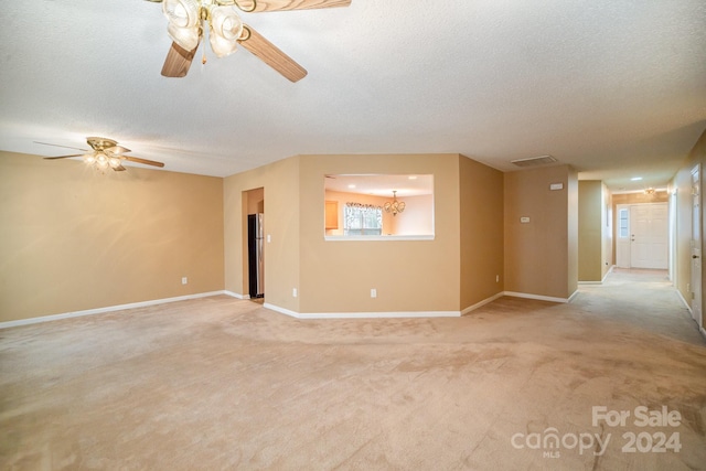 carpeted empty room with ceiling fan and a textured ceiling