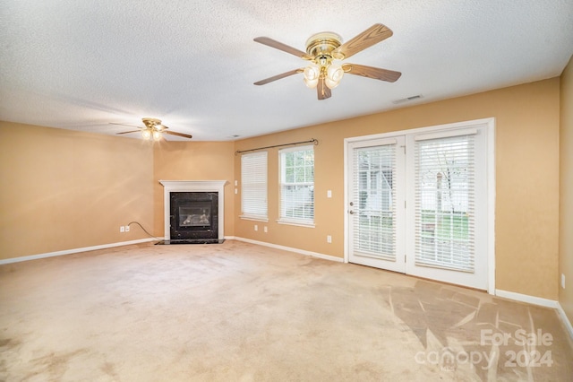 unfurnished living room with a fireplace, ceiling fan, plenty of natural light, and light colored carpet