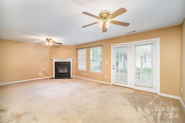 105 Ranlo Ave, Gastonia, NC 28054 - unfurnished living room with a ceiling fan, a fireplace with flush hearth, baseboards, a textured ceiling, and carpet flooring