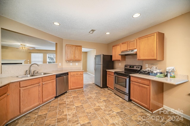 kitchen featuring a textured ceiling, ceiling fan, sink, and stainless steel appliances