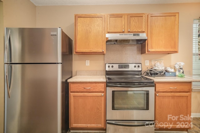 kitchen featuring decorative backsplash, light brown cabinetry, and appliances with stainless steel finishes