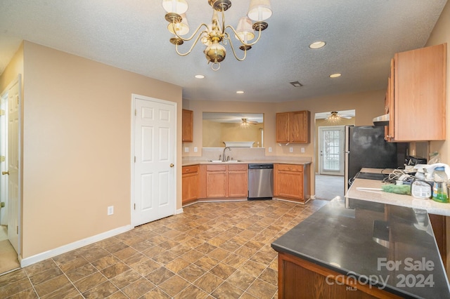 kitchen with a textured ceiling, sink, pendant lighting, and stainless steel dishwasher