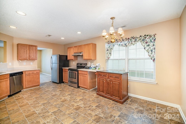 kitchen featuring decorative light fixtures, a textured ceiling, stainless steel appliances, and a notable chandelier