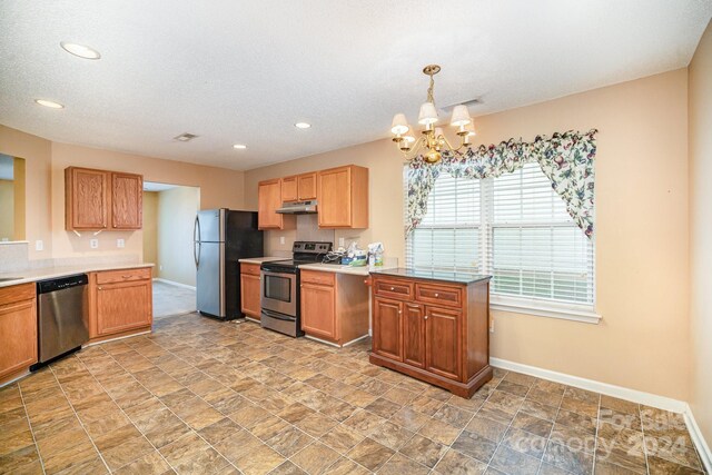 105 Ranlo Ave, Gastonia, NC 28054 - kitchen featuring stainless steel appliances, under cabinet range hood, baseboards, a chandelier, and light countertops