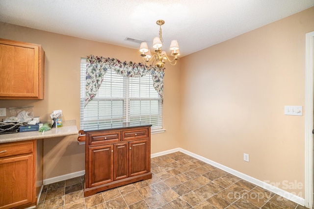 kitchen featuring a textured ceiling, decorative light fixtures, and an inviting chandelier