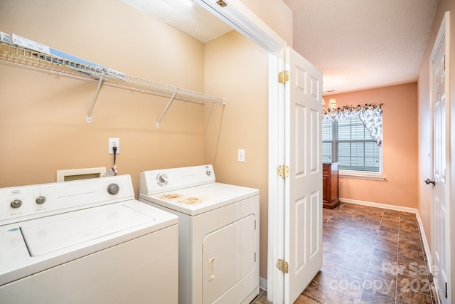 washroom with independent washer and dryer, a textured ceiling, and an inviting chandelier