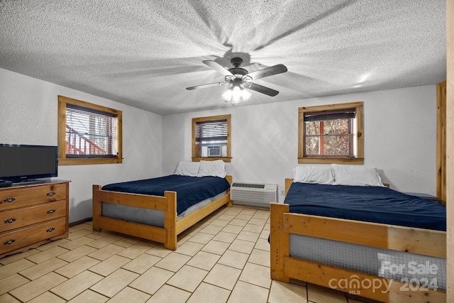 bedroom featuring ceiling fan, a wall mounted air conditioner, cooling unit, and a textured ceiling