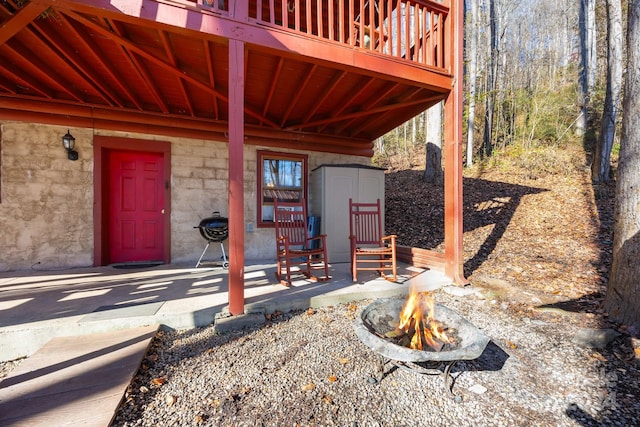 view of patio / terrace featuring area for grilling, a shed, a deck, and an outdoor fire pit