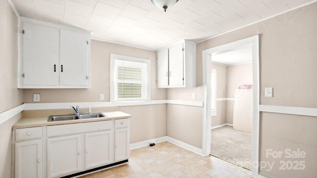 408 E Washington Ave, Bessemer City, NC 28016 - kitchen featuring light countertops, light floors, a sink, and white cabinets