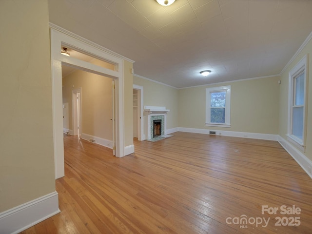 unfurnished living room with built in features, light hardwood / wood-style flooring, and ornamental molding