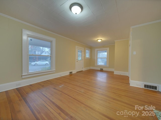 unfurnished room with ornamental molding and light hardwood / wood-style floors