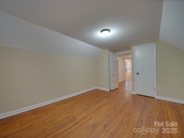 bonus room featuring vaulted ceiling and light wood-type flooring