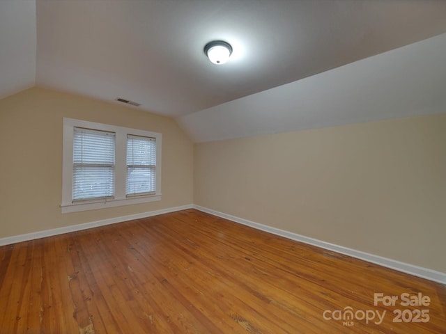 bonus room with lofted ceiling and light wood-type flooring