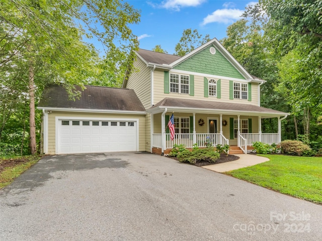 view of front of property with a front lawn, a porch, and a garage