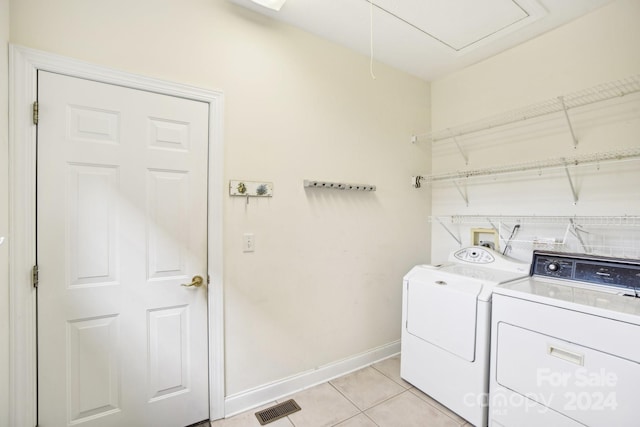 laundry area with light tile patterned floors and washing machine and dryer