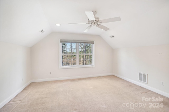 additional living space featuring light carpet, ceiling fan, and vaulted ceiling