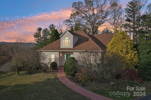 new england style home featuring a lawn