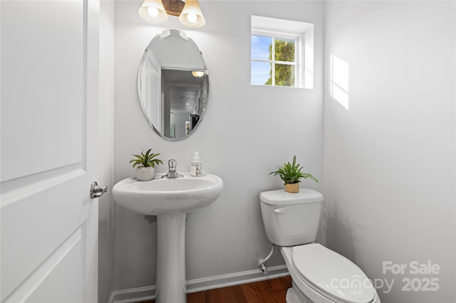 bathroom featuring wood-type flooring and toilet