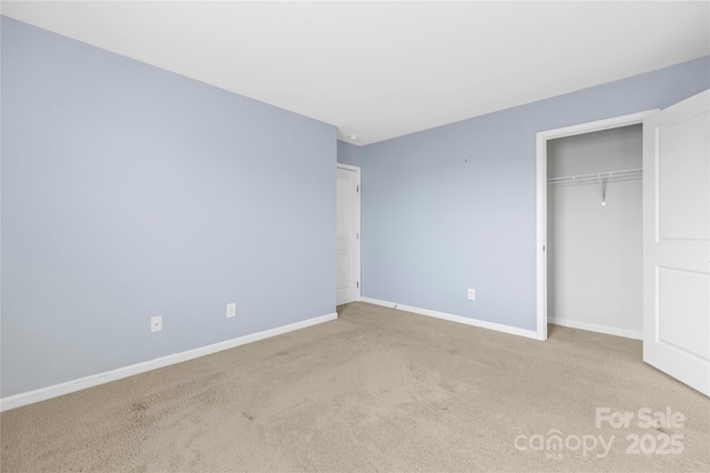 unfurnished bedroom with light colored carpet and a closet