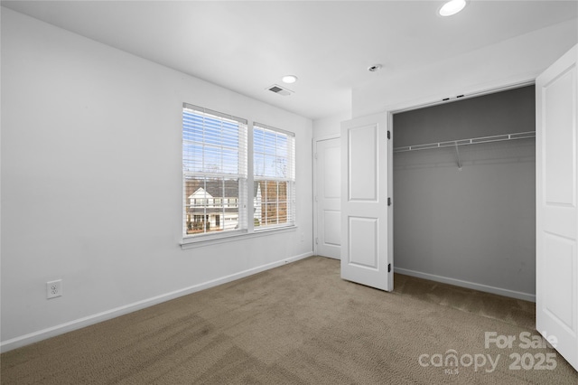 unfurnished bedroom featuring carpet flooring and a closet