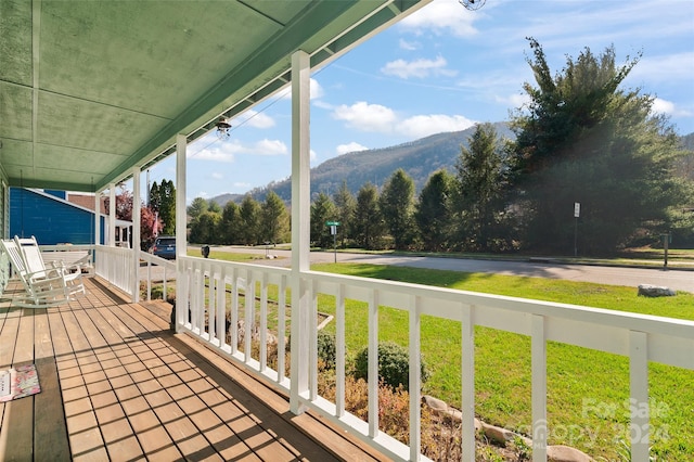 balcony featuring a mountain view and a porch