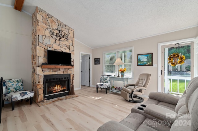 living room with a fireplace, a wealth of natural light, light hardwood / wood-style flooring, and vaulted ceiling