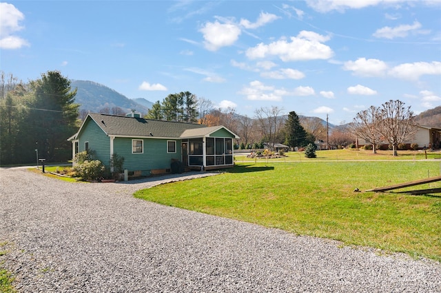 exterior space featuring a mountain view, a sunroom, and a front yard