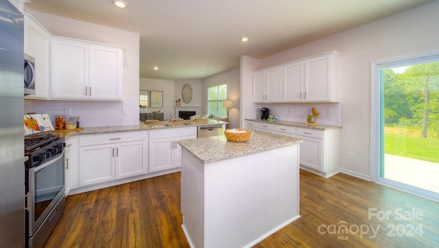 kitchen featuring backsplash, white cabinets, dark hardwood / wood-style floors, and appliances with stainless steel finishes