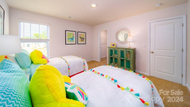 bedroom with carpet, a walk in closet, and a closet