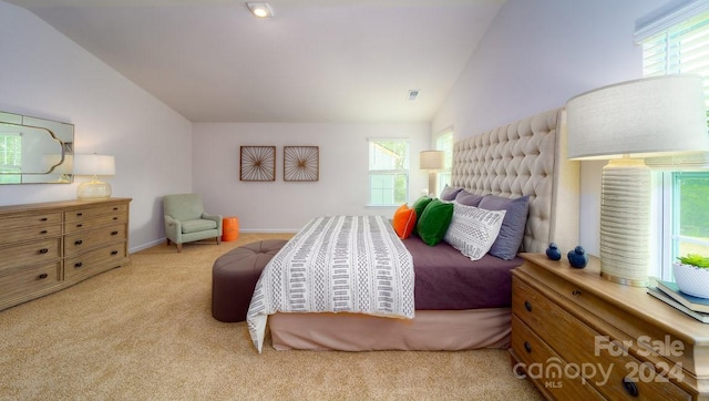 bedroom with multiple windows, light carpet, and vaulted ceiling