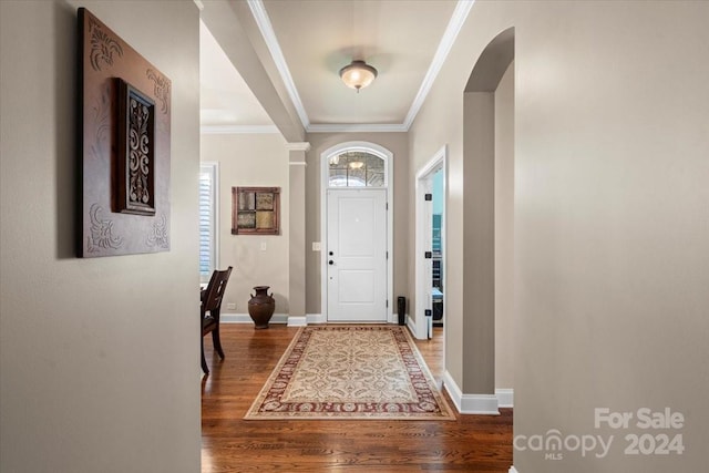 foyer with wood-type flooring and crown molding