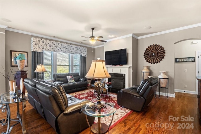 living room with ornamental molding, ceiling fan, and dark wood-type flooring