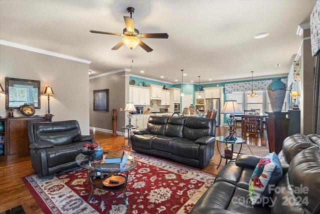 living room with hardwood / wood-style flooring, ceiling fan, and crown molding