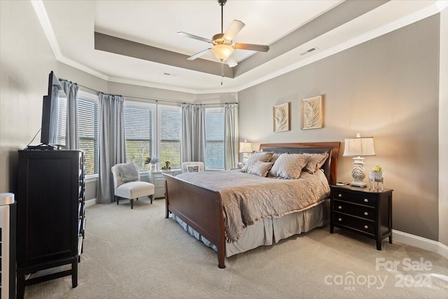 bedroom featuring a raised ceiling, ceiling fan, crown molding, and light colored carpet