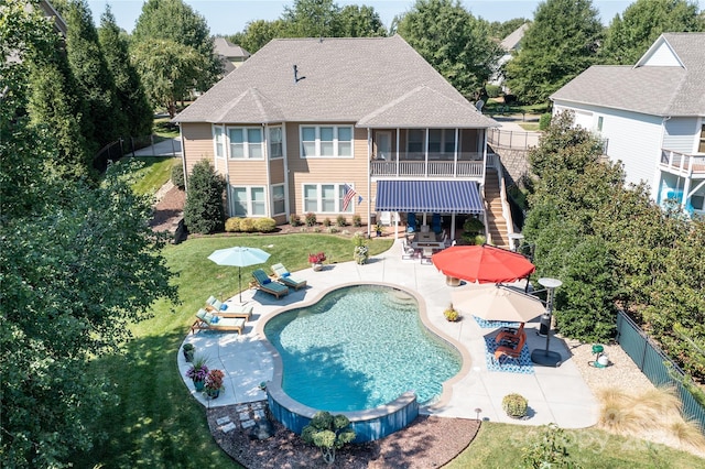 back of house with a yard, a fenced in pool, a patio area, and a sunroom