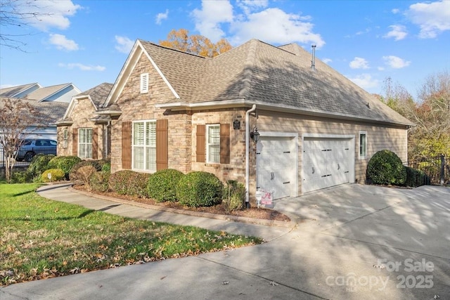 view of side of home with driveway, a garage, stone siding, and roof with shingles