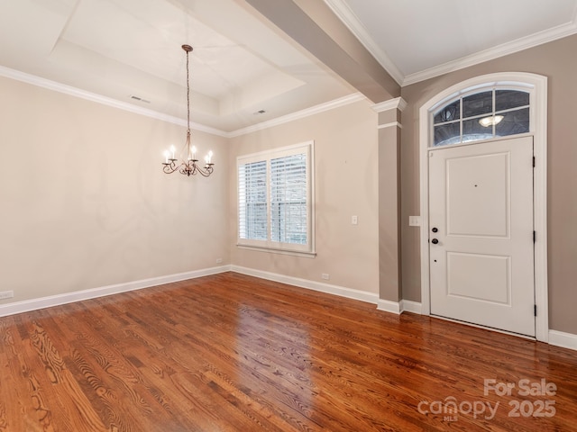 entrance foyer featuring a raised ceiling, baseboards, a notable chandelier, wood finished floors, and visible vents