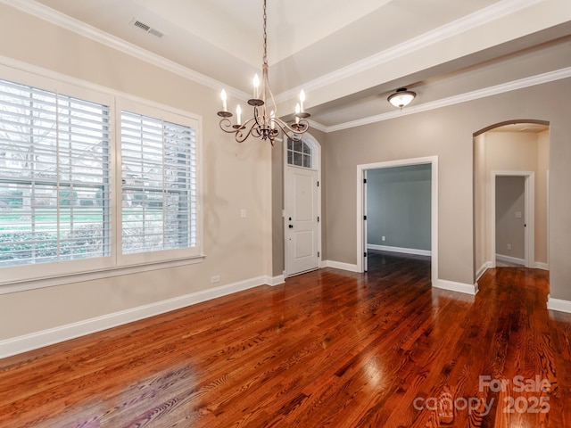 unfurnished dining area with baseboards, dark wood-type flooring, visible vents, crown molding, and arched walkways