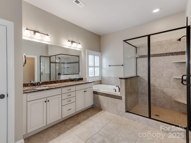 bathroom with a sink, a shower stall, a garden tub, and visible vents