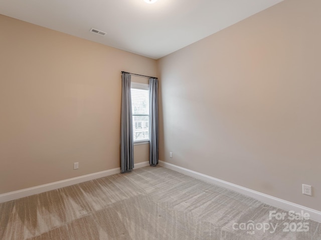 empty room featuring light colored carpet, baseboards, and visible vents