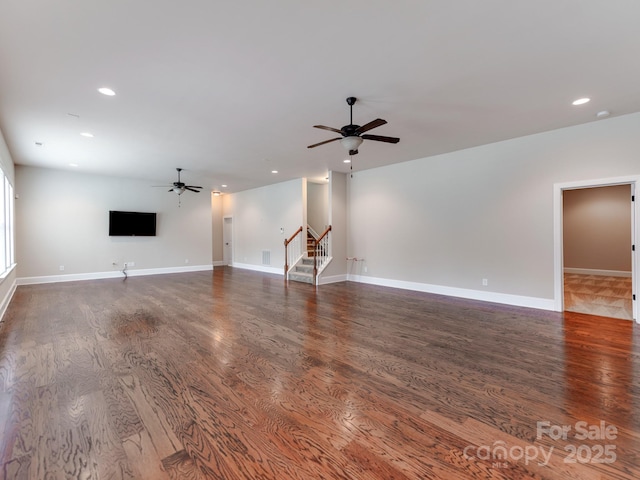 unfurnished living room with baseboards, dark wood finished floors, a ceiling fan, stairs, and recessed lighting