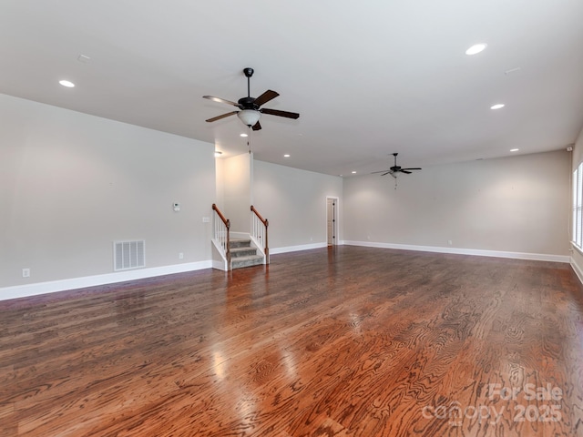 spare room with stairway, recessed lighting, dark wood-type flooring, and visible vents