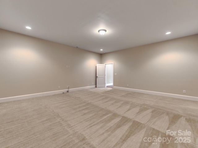 spare room with recessed lighting, light carpet, and baseboards