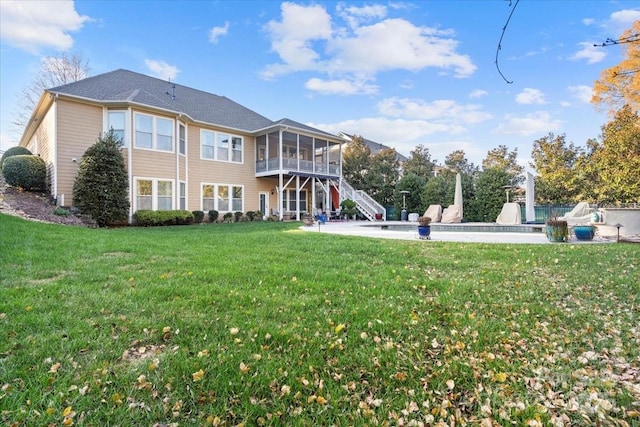 rear view of property featuring a sunroom, an outdoor pool, stairs, a patio, and a yard