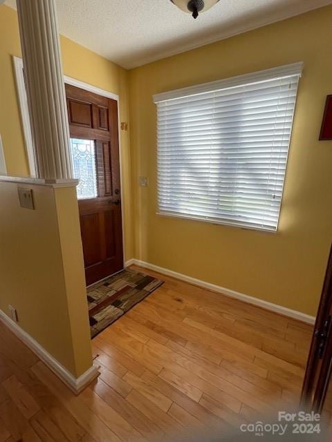 entryway with light hardwood / wood-style floors and a textured ceiling