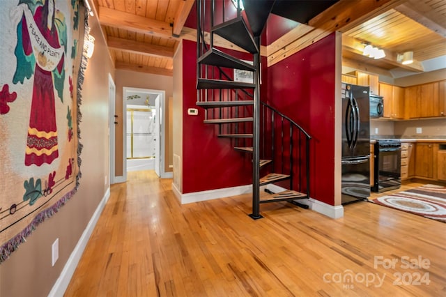 stairway featuring hardwood / wood-style floors, beamed ceiling, and wooden ceiling