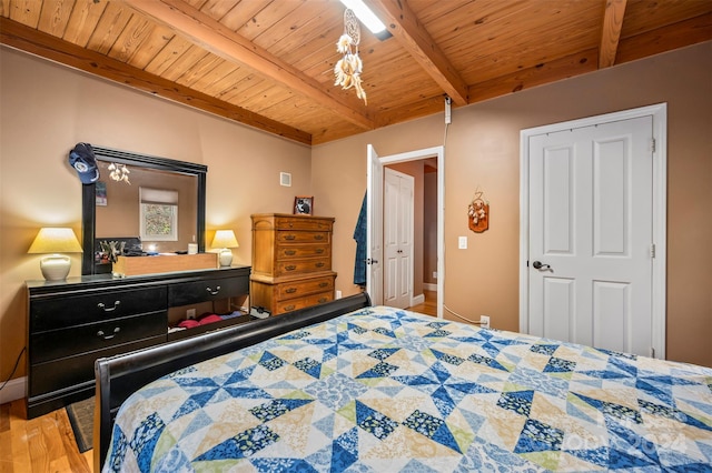 bedroom featuring beamed ceiling, light wood-type flooring, and wooden ceiling