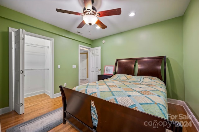 bedroom featuring wood-type flooring, a closet, and ceiling fan