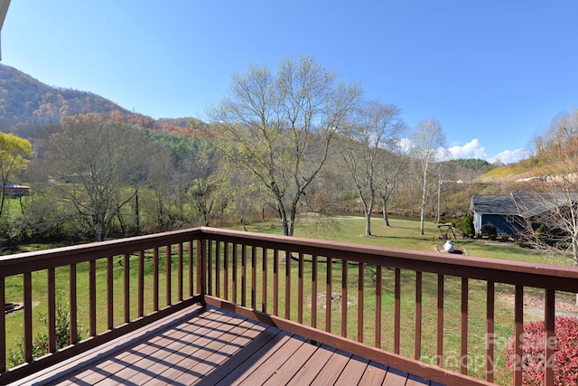 wooden terrace with a mountain view and a yard