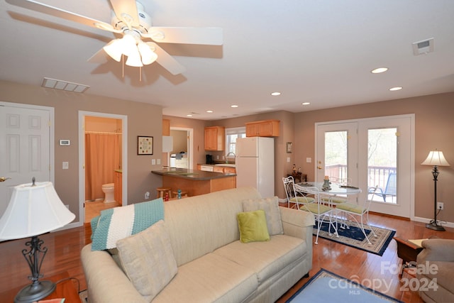 living room with ceiling fan, plenty of natural light, and light hardwood / wood-style flooring